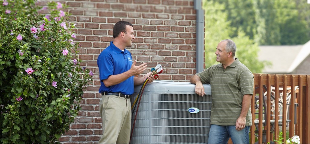 Air conditioning technician discussing AC with a homeowner