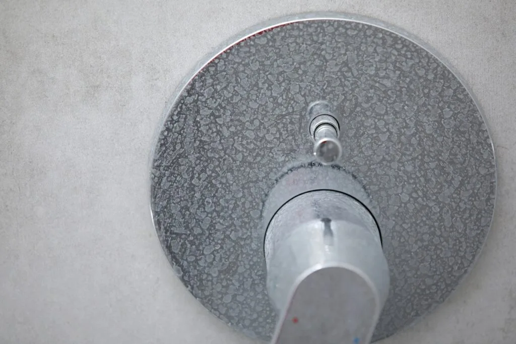 Limescale and soap scum buildup on a showerhead form hard water
