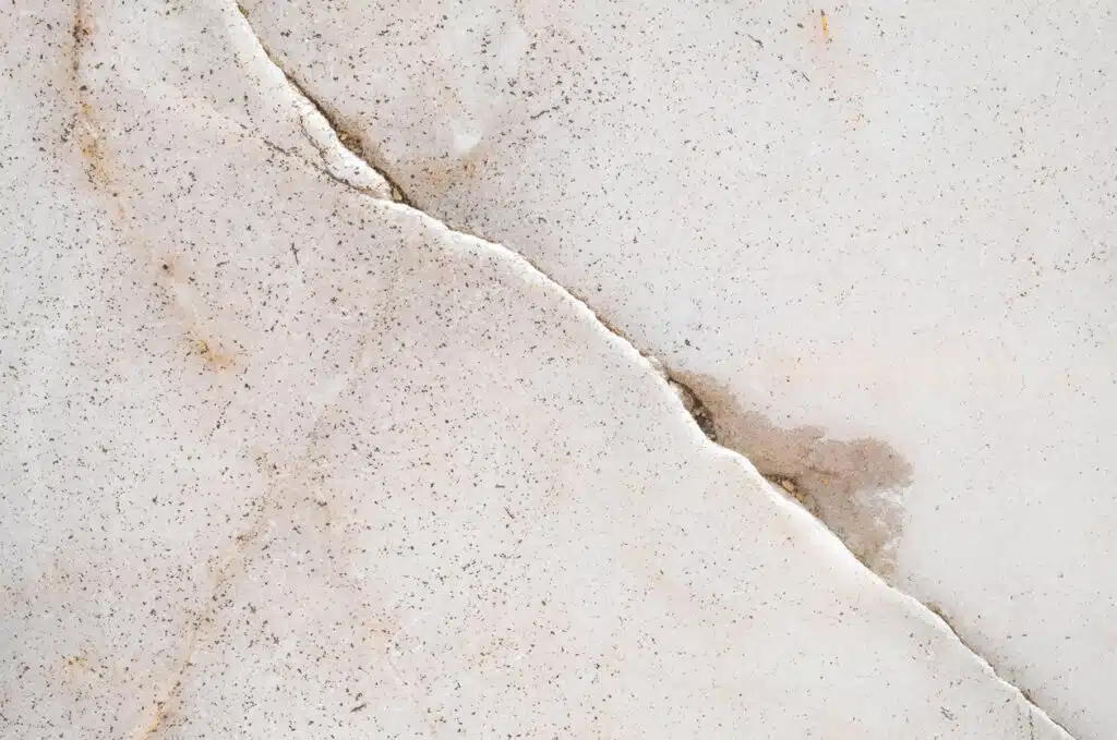 Closeup surface cracked marble floor with water seeping through